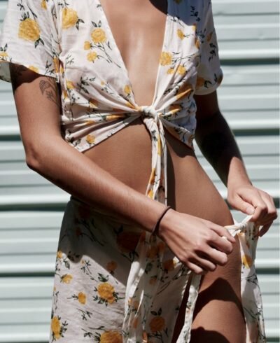 bodytite patient model in a flowery top tying on a skirt